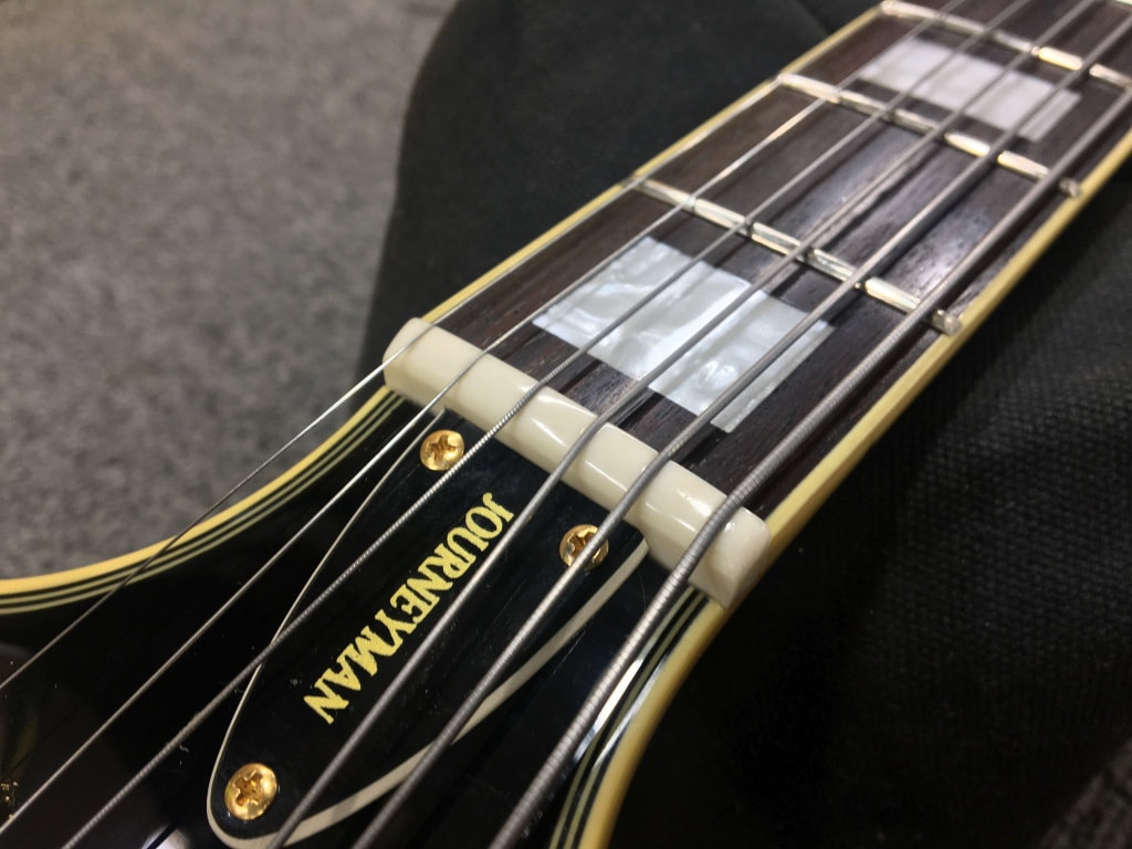 Imagen de una cejuela de guitarra bien elaborada, hecha de hueso de alta calidad.