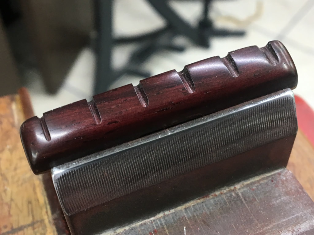 Foto de una cejuela de guitarra fabricada en madera