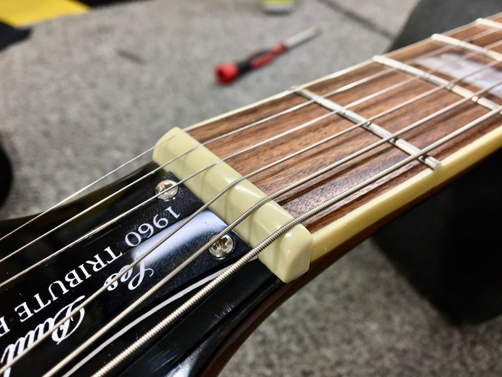 Foto de cejilla de plástico en guitarra epiphone
