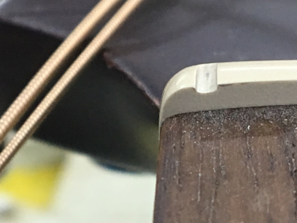 Foto de la ranura para la cuerda de una cejilla de micarta