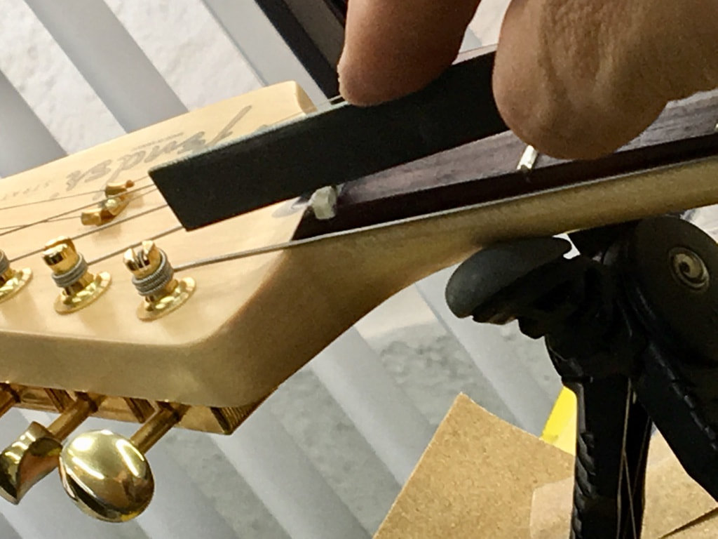 Foto del tallado de la ranura de cejilla tipo Fender